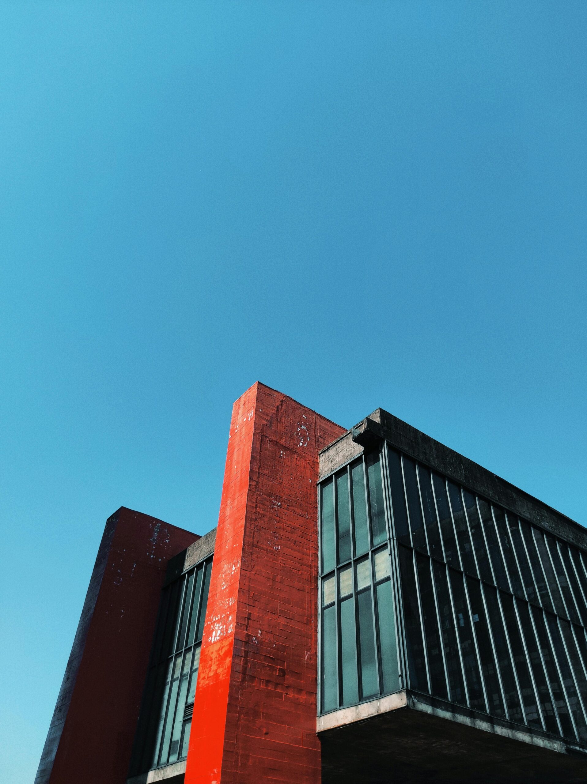 Low-angle view of a modernist building in São Paulo against a clear blue sky.
